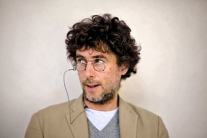 Carlo Valsecchi mit Brille und beiger Jacke.