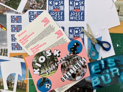 Schreibtisch mit Bastelmaterialien und Grusskartenentwürfen.