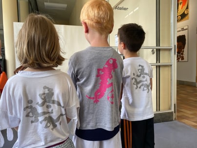 Drei Kinder in T-Shirts mit Tierdrucken im Atelier.