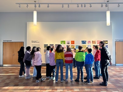 Gruppe von Schülern betrachtet Kunstwerke im Vestibül des Museum für Gestaltung Zürich.