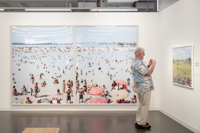 Mann betrachtet Strandfotos in Galerie.