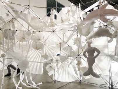 Kunstinstallation aus weissem Papier mit verschiedenen Formen.