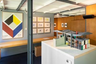 Innenraum mit Architekturmodell und Bildern an den Wänden.