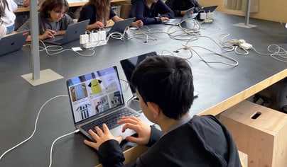 Kinder arbeiten an Laptops in einem Klassenzimmer.