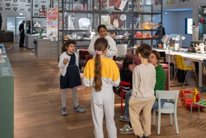 Kinder in einem Raum mit Möbeln und Dekorationen beigefügt.