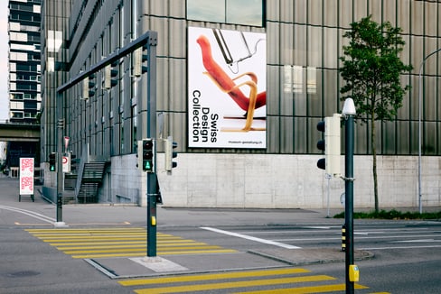 Städtische Strasse mit Plakat der Swiss Design Collection an Gebäude.