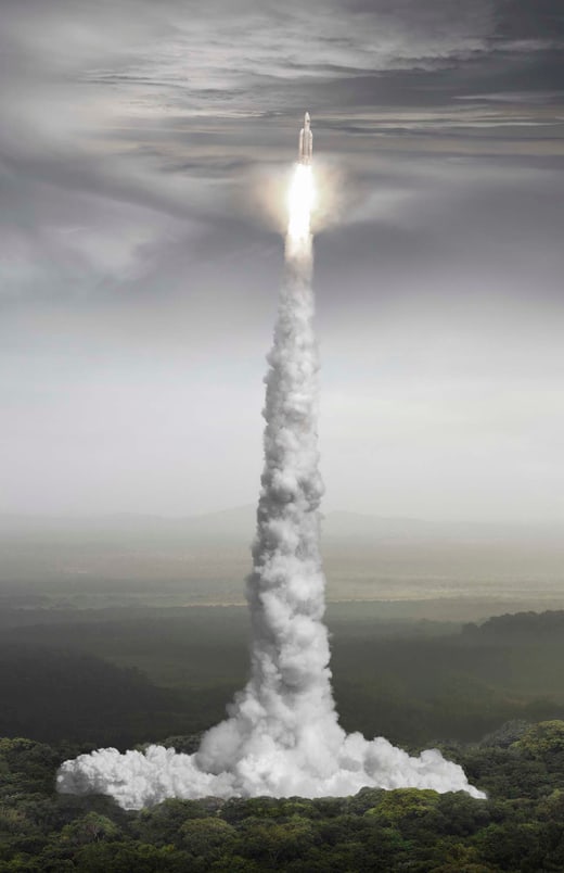 Raketa startet in den Himmel über Waldlandschaft.
