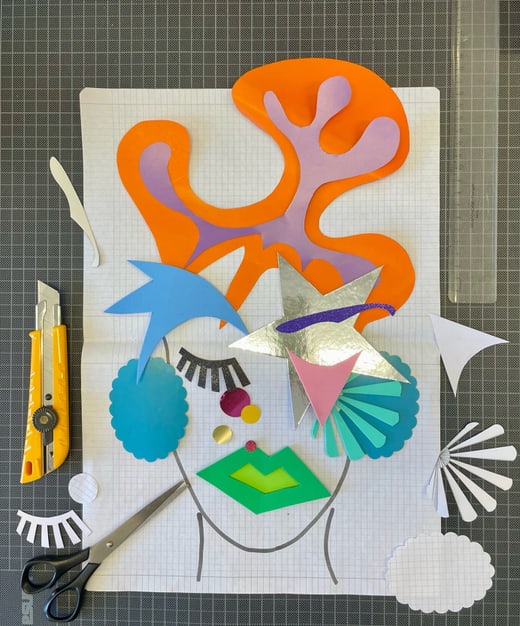 Collage aus buntem Papier auf Rasterpapier mit Bastelwerkzeugen.