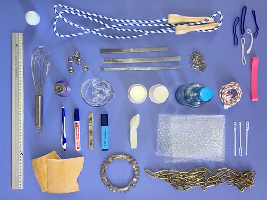 Verschiedene Alltagsgegenstände auf blauem Hintergrund angeordnet.