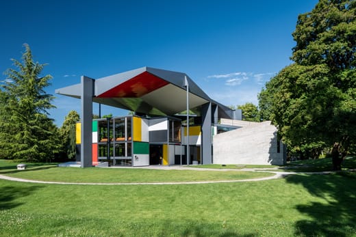 Modernes Gebäude mit bunten Fassaden im Grünen.