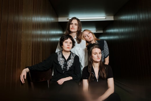 Vier Personen in einem Flur mit Holzverkleidung.