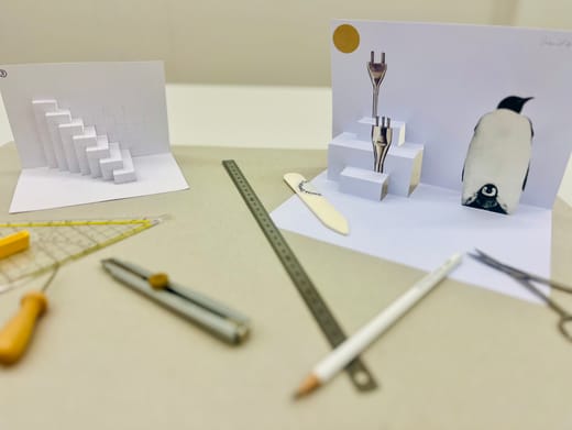 Papierkunstwerke mit Bleistift, Lineal und Werkzeugen auf Tisch.