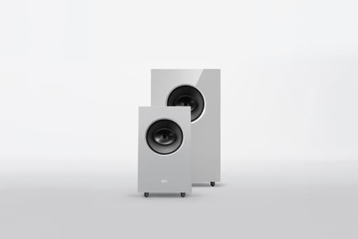 Zwei weisse Lautsprecher auf grauem Hintergrund.